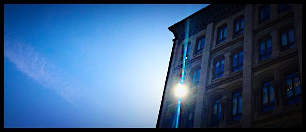 Low angle view of buildings against clear blue sky