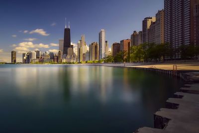 Cityscape by lake michigan against sky