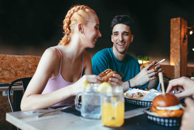 Cheerful friends having fun in fast food cafe