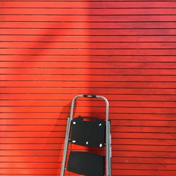 View of ladder next to red wall