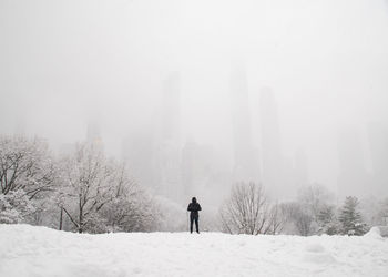 Rear view of man standing on snow covered land