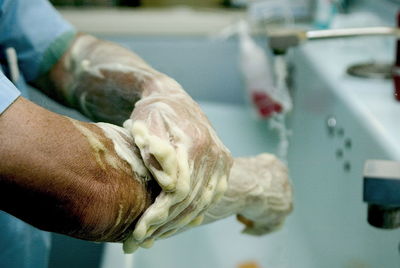 Close-up of medical doctor washing arms and hands