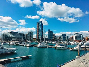 Boats in harbor against buildings in city