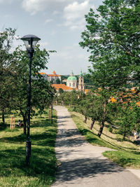 Street amidst trees and buildings against sky