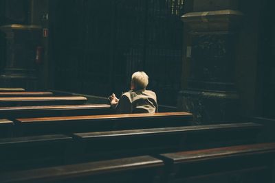 Rear view of woman praying in church