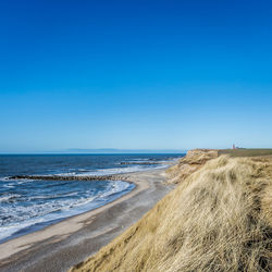 Scenic view of sea against clear blue sky