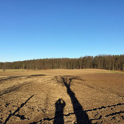 Shadows on landscape against clear blue sky