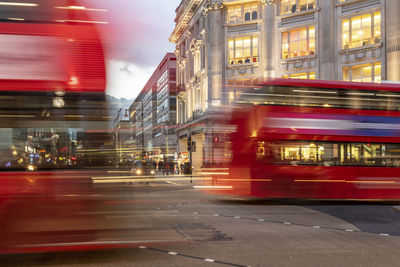 Uk, london, red double decker bus crossing oxford circus junction at dusk, blurred