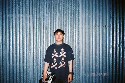 Portrait of boy standing against curtain