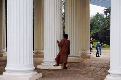 Rear view of men walking on corridor of building