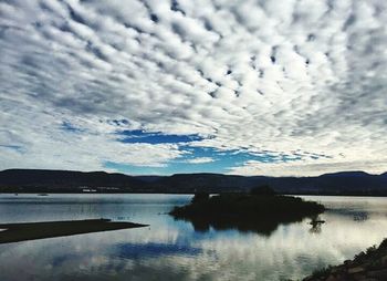 Scenic view of lake against cloudy sky