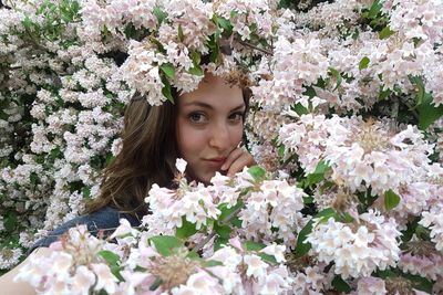 Portrait of beautiful young woman with red flowers