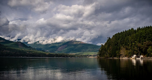 Scenic view of lake and mountains against cloudy sky