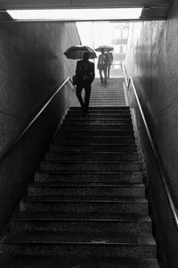 Low angle view of people moving down on steps during monsoon