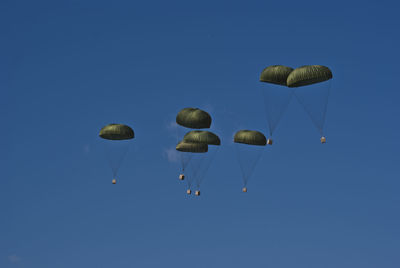 Low angle view of parachute against blue sky