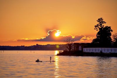 Scenic view of lake against orange sky