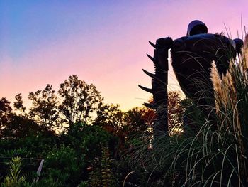 Rear view of man on field against sky at sunset