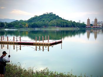 Rear view of people in lake against sky