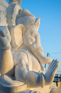 Low angle view of statue against building against sky