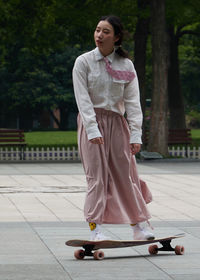 Full length of woman standing on footpath