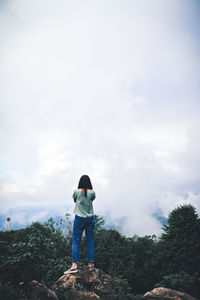 Rear view of woman standing against sky