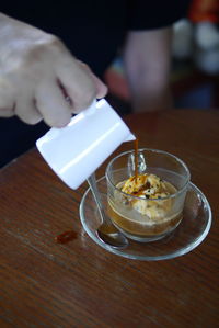 Midsection of person holding drink on table