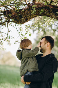 Father and son standing on tree