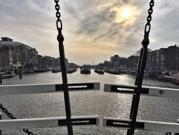 Close-up of bridge over river in city against sky