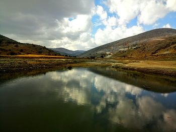 Scenic view of lake against cloudy sky