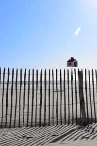 Low angle view of fence against clear blue sky