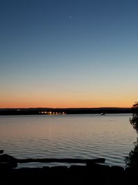 Scenic view of lake against clear sky during sunset