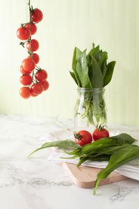 Ramsons and cherry tomatoes on marble work surface in a kitchen. healthy food concept