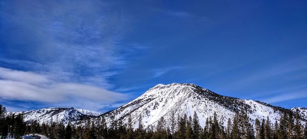 Scenic view of snowcapped mountains against blue sky