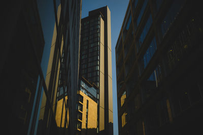 Low angle view of buildings against clear sky at night