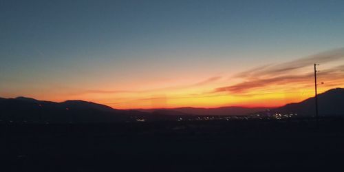 Scenic view of silhouette mountains against sky during sunset