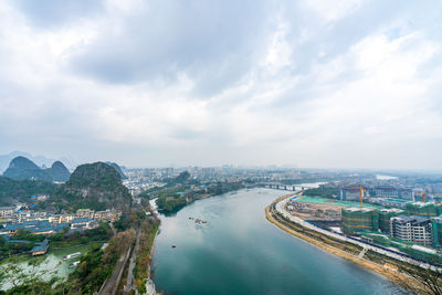 High angle view of river amidst buildings in city against sky