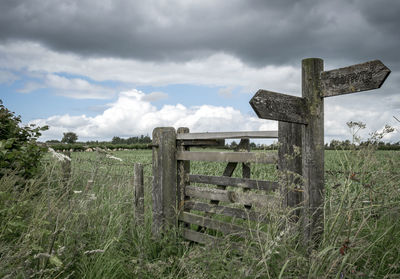 Wooden posts on field against sky