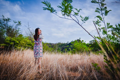 Woman standing on field against sky