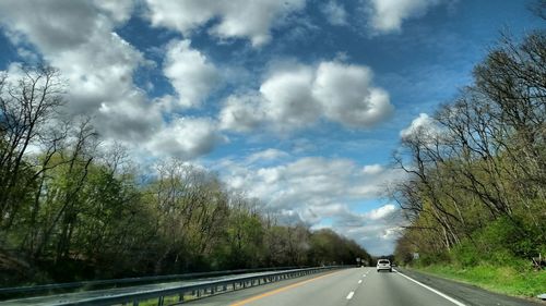 Empty road against cloudy sky