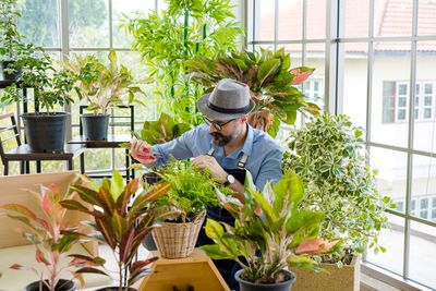 Man standing by potted plants
