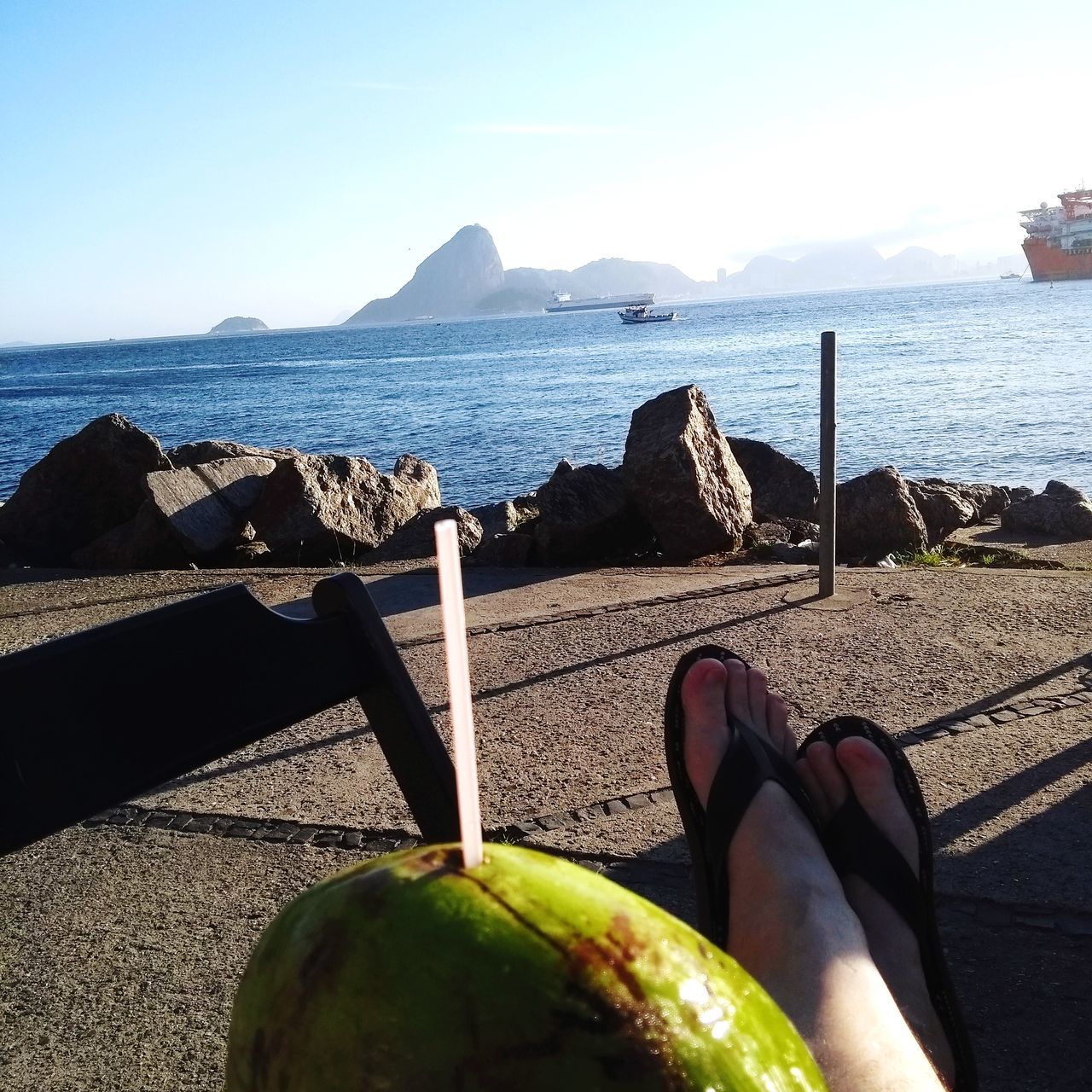 LOW SECTION OF PERSON ON TABLE AT BEACH