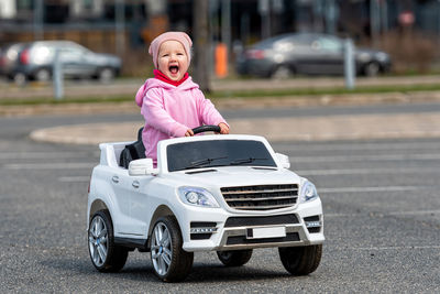 Little girldriving a toy car. little driver, childrens car, concept of road safety, children in car