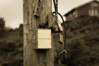 Abandoned fuse box on wooden pole