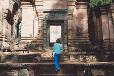 Rear view of woman standing against building