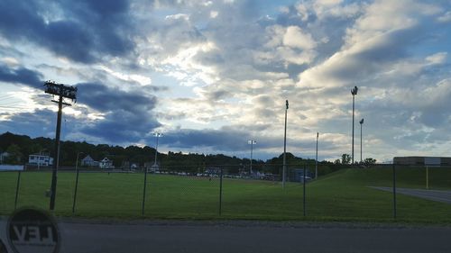 View of field against cloudy sky