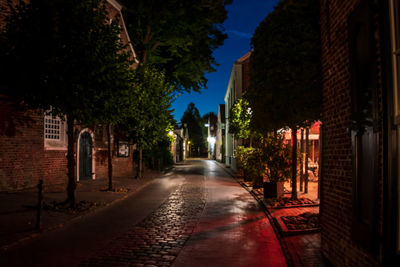 Street amidst buildings at night