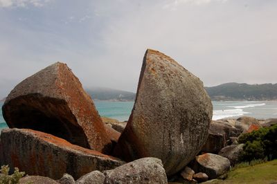 Rocks on beach against sky