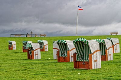 Scenic view of flag on field against sky