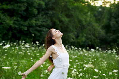 Young woman standing amidst plants