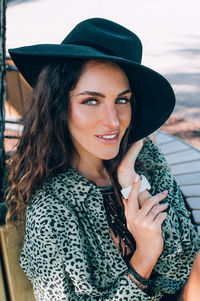 Portrait of beautiful stylish young woman wearing black felt hat smiling millennials generation.